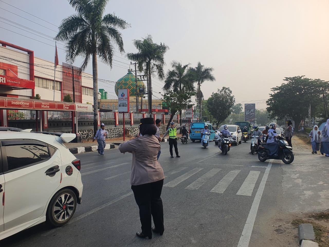 Polisi Siaga Menata Kemacetan dan Seberangkan Anak Sekolah di Kota Kendari